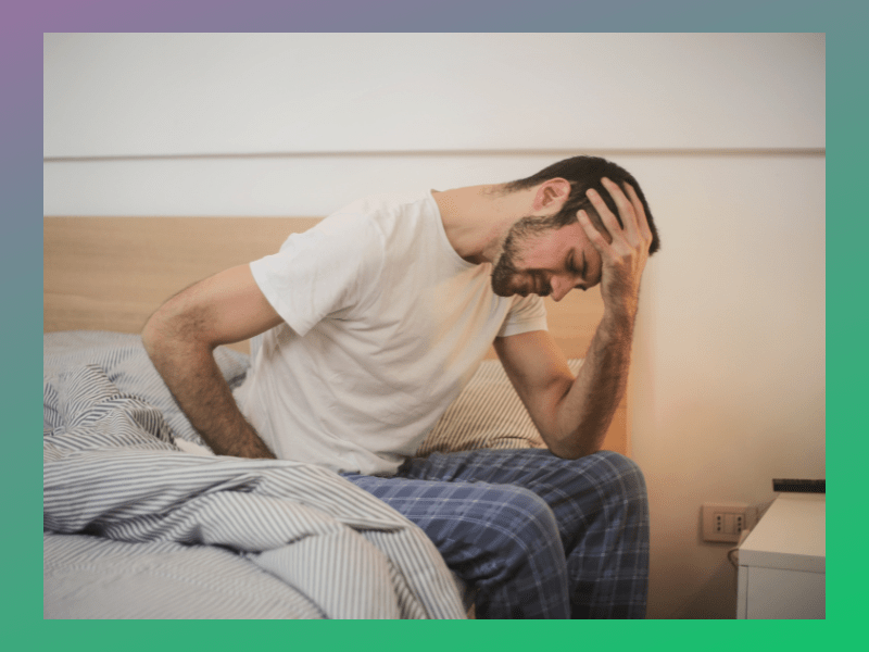 man-sitting-on-edge-of-bed